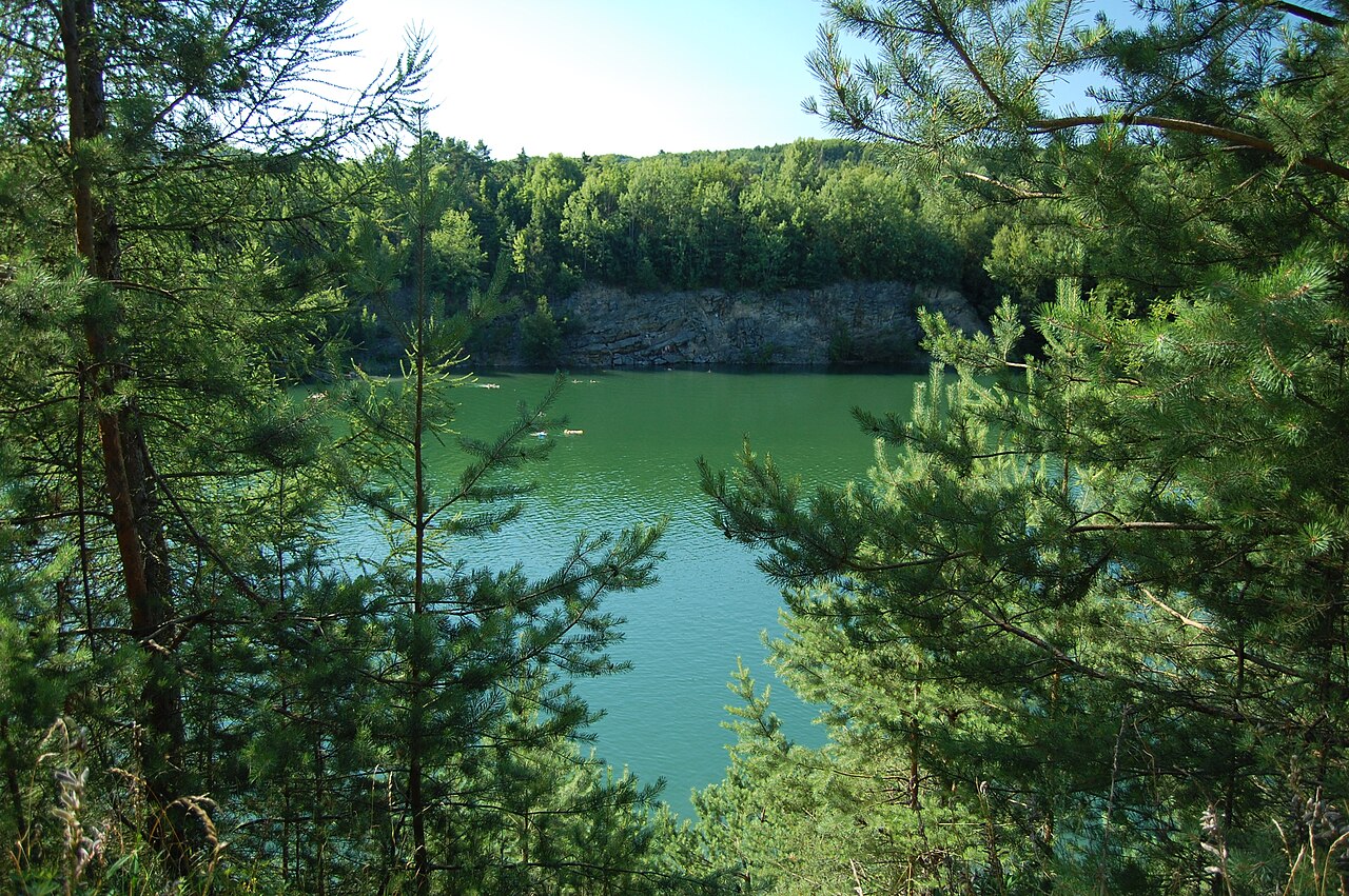 Zatopený lom u obce Nová Ves. Autor: xkomczax, licence CC BY-SA 3.0. Zdroj: Zdroj: <a href="https://commons.wikimedia.org/wiki/File:Zatopen%C3%BD_lom_u_obce_Nov%C3%A1_Ves_-_pohled_sm%C4%9Brem_k_silnici,_Litovel,_okres_Olomouc.jpg">Wikimedia Commons</a>